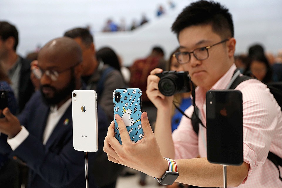 Посетитель презентации Apple фотографирует новинки.