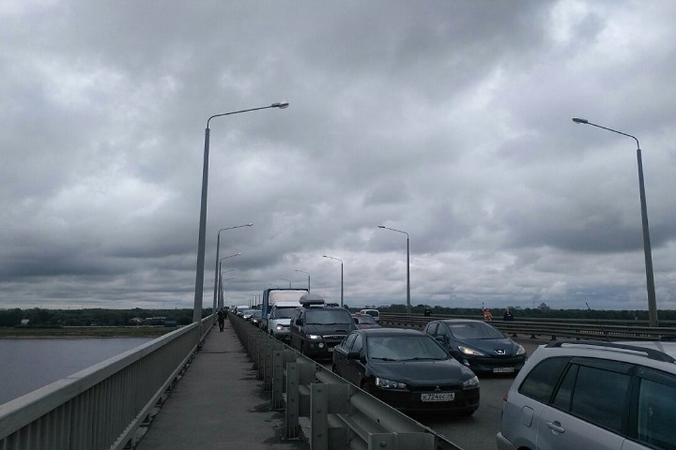 Многие люди идут через мост пешком.