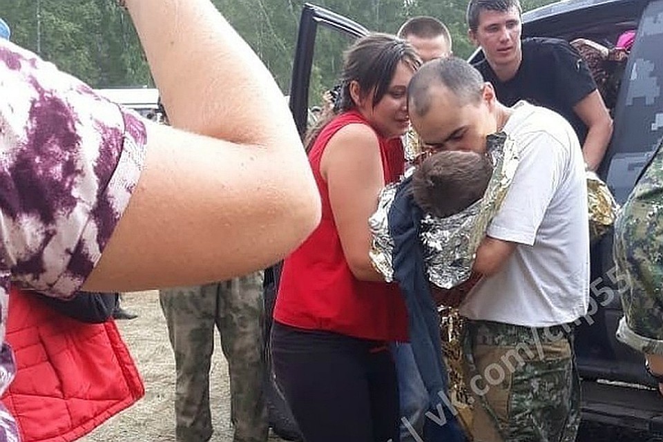 Первое фото после нахождения мальчика. Его передают в руки счастливым родителям. Фото: «ЧП Омск»