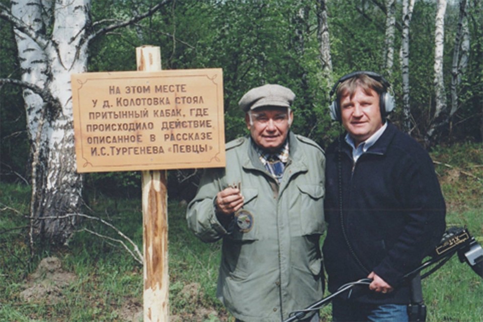 Василий Михайлович Песков с установленной памятной доской на месте Притынного кабака, Владимир Зайцев (справа) с металлоискателем, который помог найти на месте предполагаемого размещения питейного заведения оброненные монеты позапрошлого века.