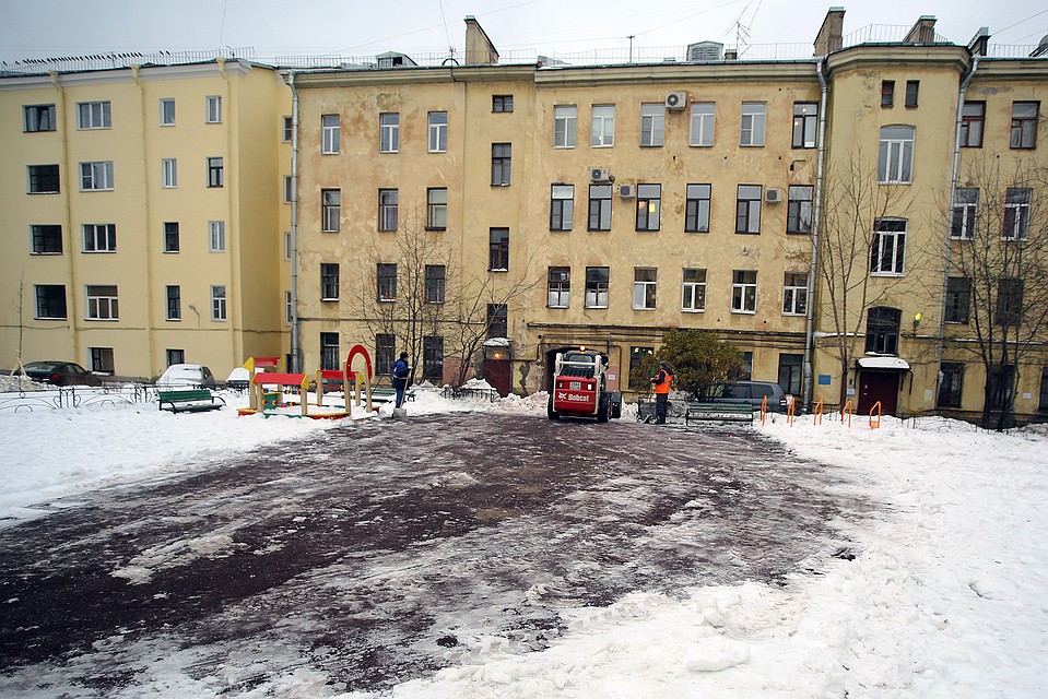 Во дворе, где произошла трагедия, рабочие убирают следы взрыва.