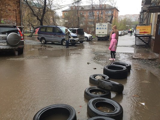Чтобы пройти через затопленные улицы, горожанам приходится преодолевать самую настоящую полосу препятствий из автомобильных шин, досок и прочих предметов.