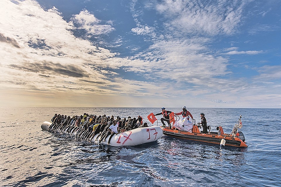 Вот так представители международного НПО SOS Mediterranee (на фото - справа) «спасают» 130 чернокожих мигрантов, едва отплывших от побережья Ливии. Теперь их доставят в Италию и получат за это хорошие деньги. Фото: GLOBAL LOOK PRESS