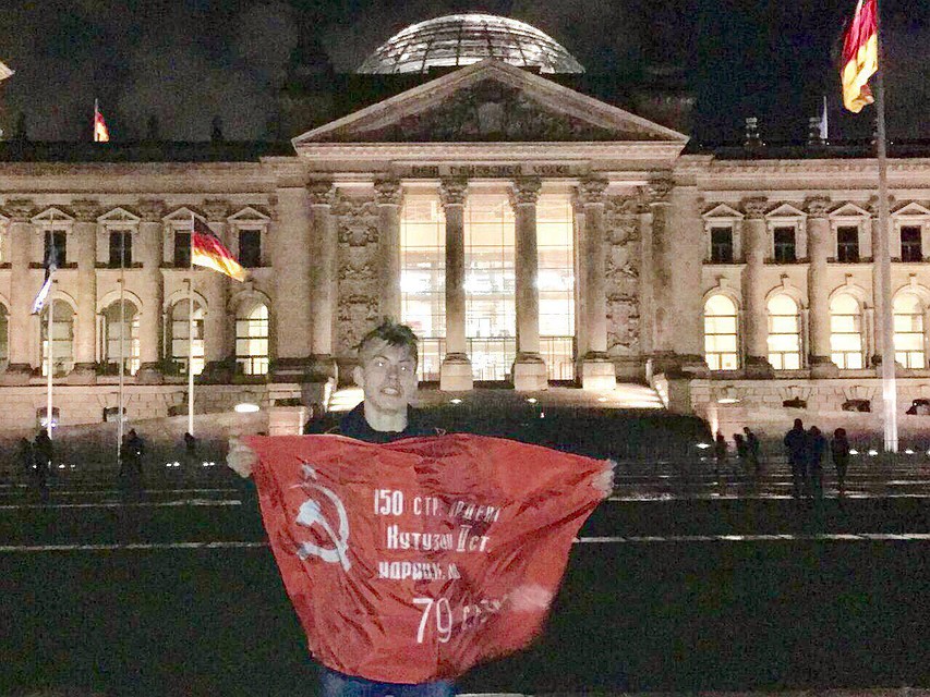 Николай сфотографировался возле Рейхстага со знаменем Победы. Фото: Из личного архива