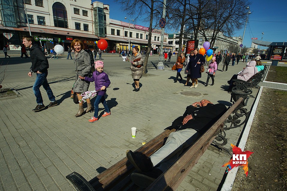 Екатеринбург. Участники первомайской демонстрации профсоюзов проходят мимо спящего на скамейке мужчины в день весны и труда. 1,05,2017 Фото: Алексей БУЛАТОВ