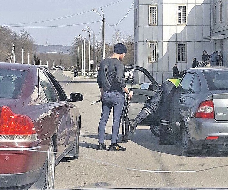 Этот шедевральный кадр разлетелся по соцсетям в начале весны. Инспектор осматривает машину, дав подержать водителю свои жезл и калаш. По-братски, по-кавказски! Фото: youtube.com