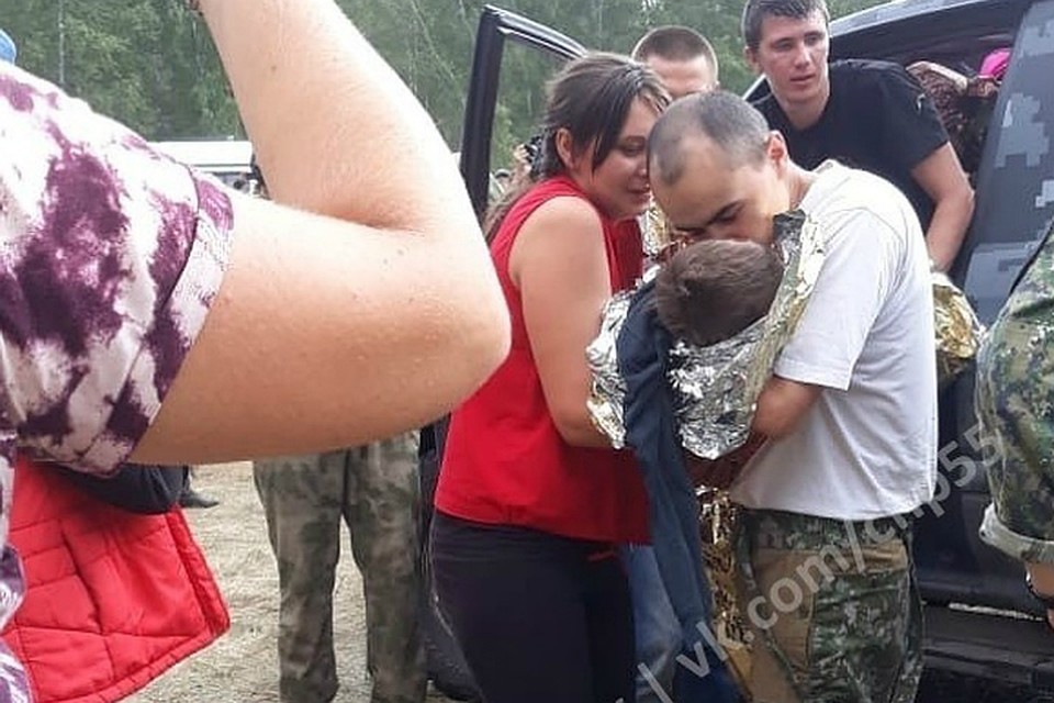 Первое фото после нахождения мальчика. Его передают в руки счастливым родителям.