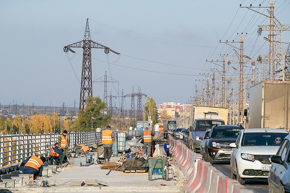 На мосту Волжской ГЭС рабочие готовятся укладывать асфальт.