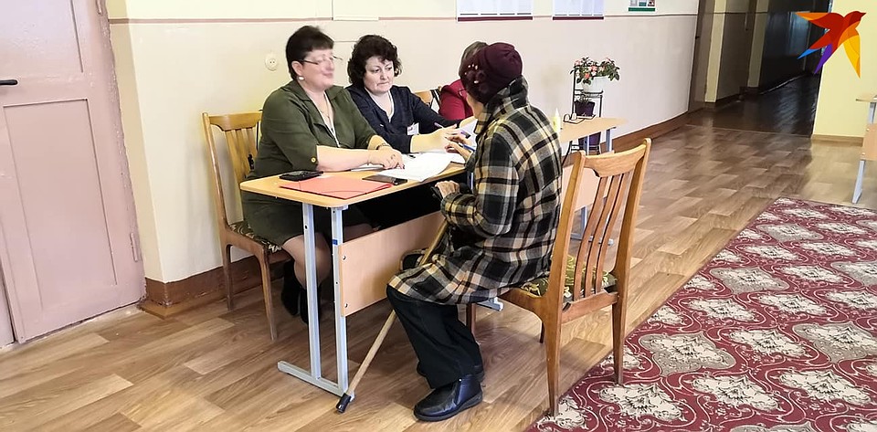 Пожилую учительницу усадили на стул, пока ее регистрировали - в деревне учителя по-прежнему в почете. Фото: Раиса ЮДИНА