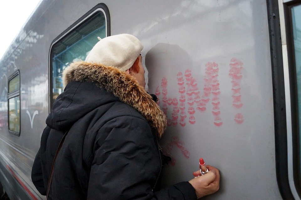 Жительница Севастополя Александра Михайловна от счастья целует первый поезд из Питера. Фото: Анастасия ЖУКОВА