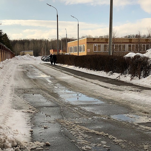 Люди спокойно гуляют около больницы без масок.